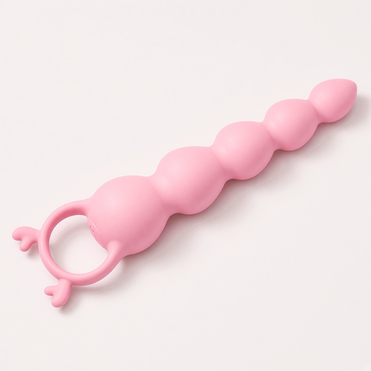 Hirni massager lying flat, side view of the beads and antler ring