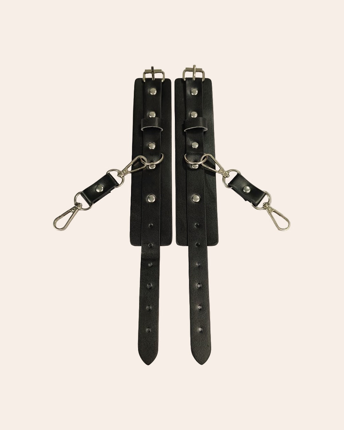 Qaid cuffs laid flat, adjustable buckle straps and clip hooks