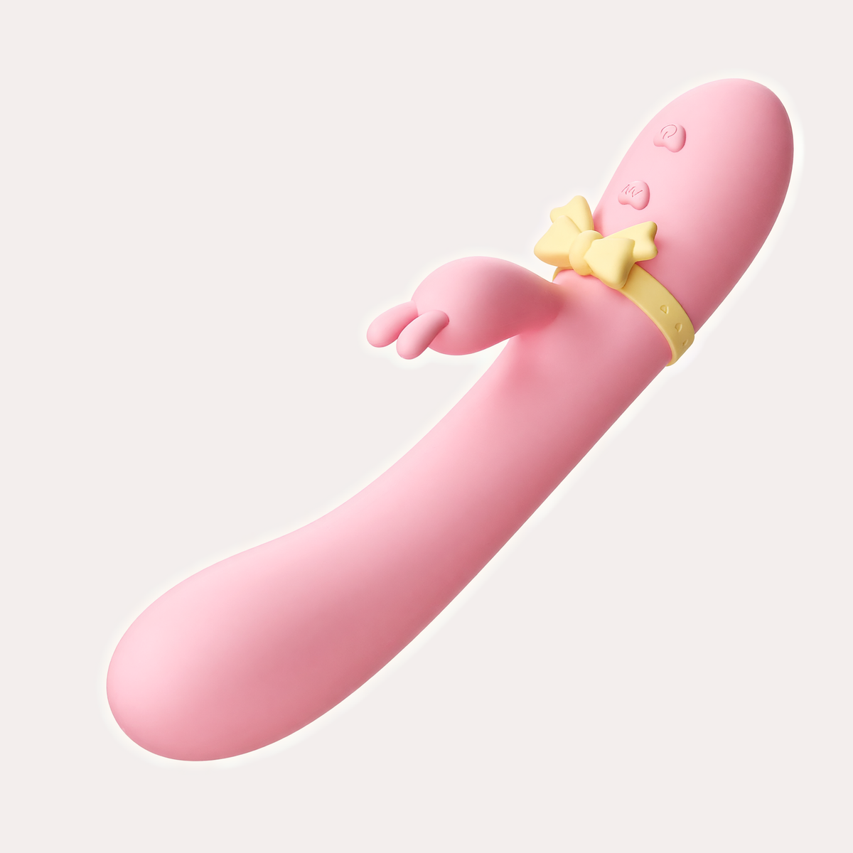 Jhankaar warming dual massager in pink with a yellow bow ring, diagonal view